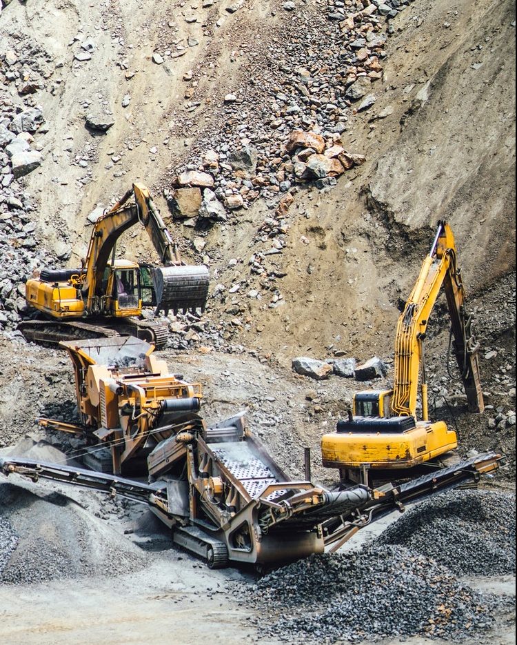 Industrial machinery and heavy duty excavators working at rock quarry