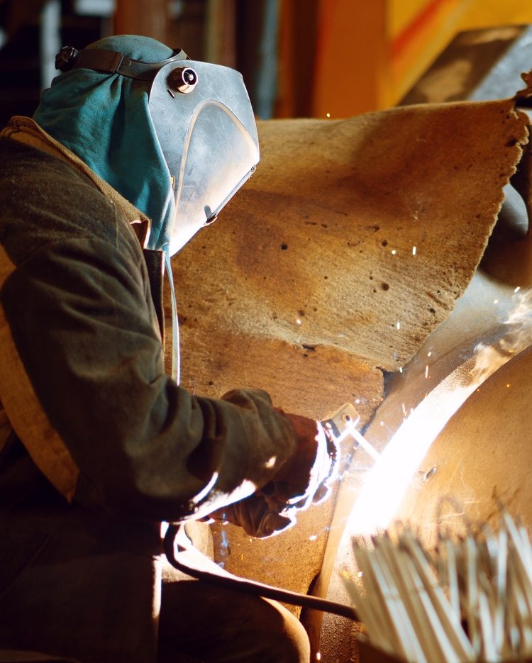 Welder in mask works with metal construction